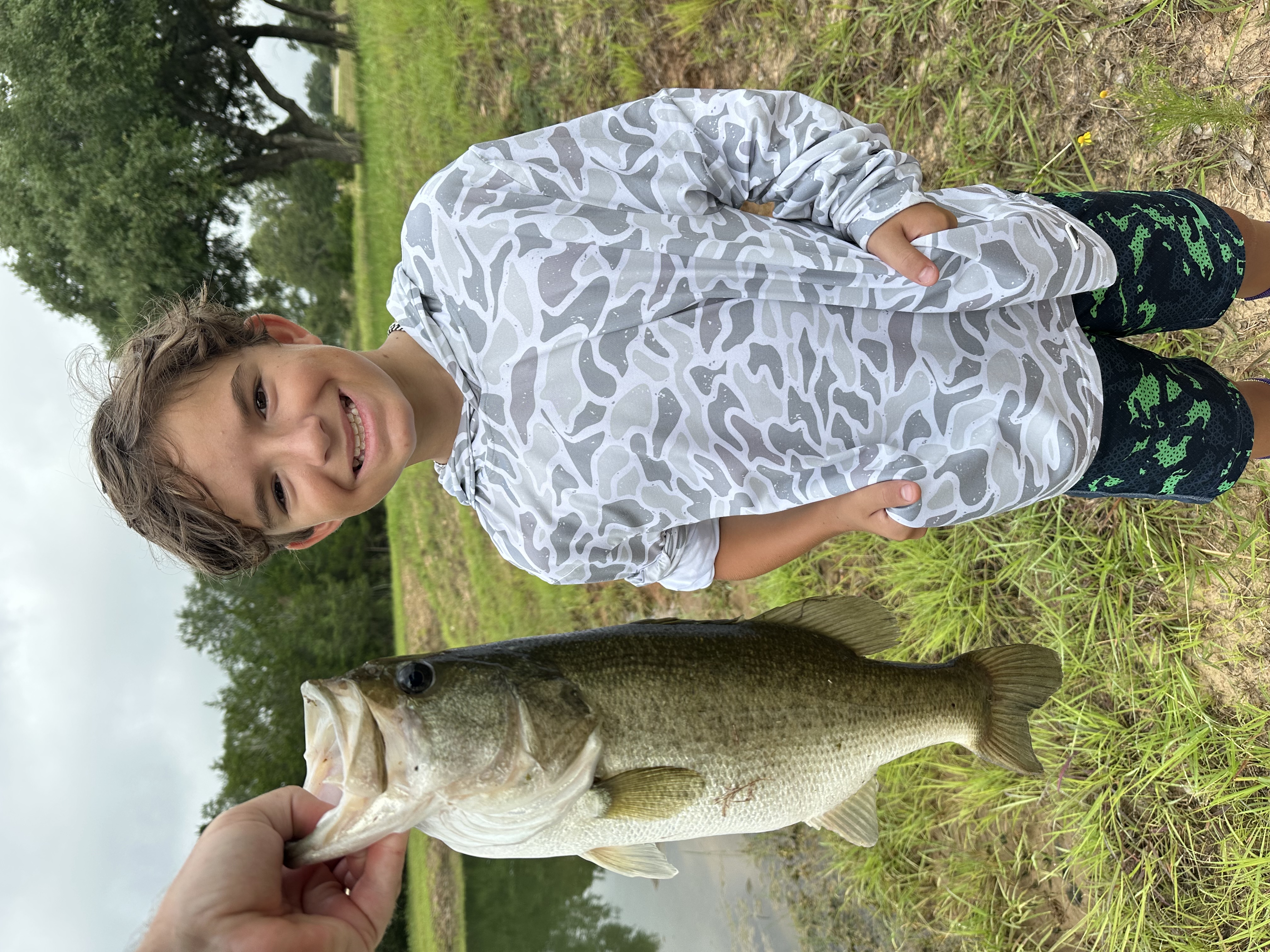 Angler holding a largemouth bass caught on a Chuck's Bass Candy handcrafted soft plastic lure — First cast, first fish. That's the candy.