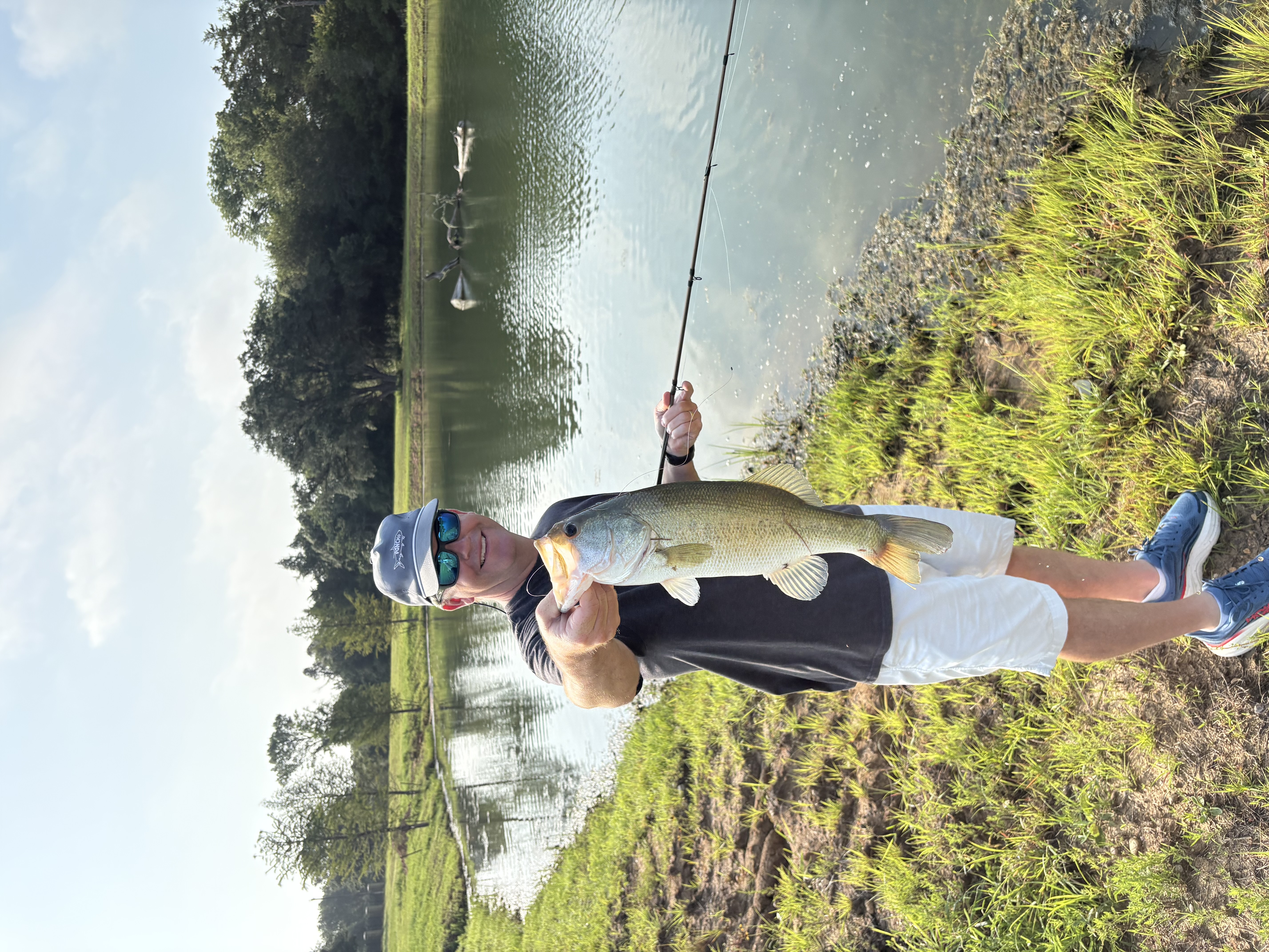 Angler holding a largemouth bass caught on a Chuck's Bass Candy handcrafted soft plastic lure — Dad's afternoon slab.
